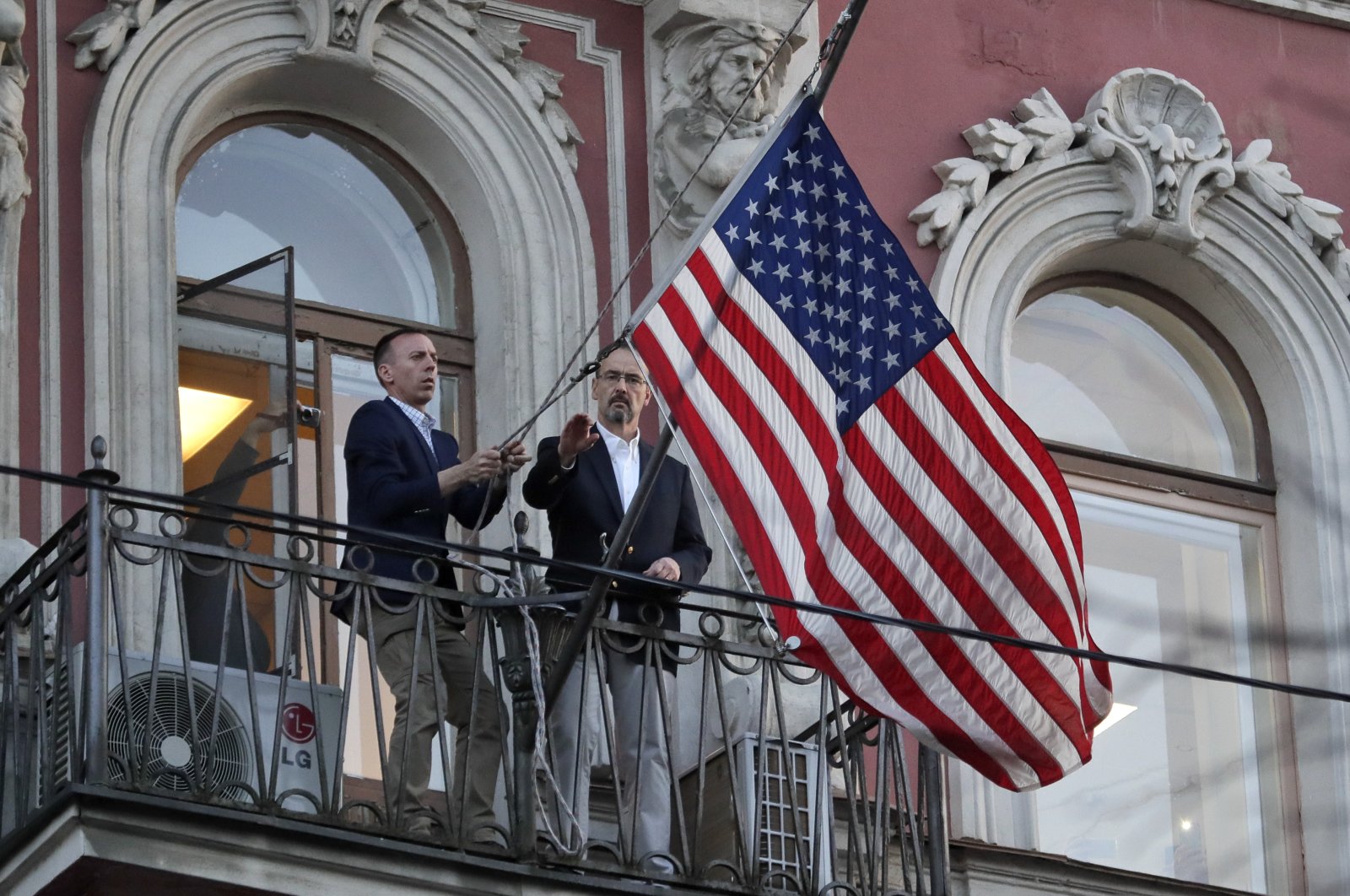 Consulate employees remove the U.S flag at the U.S. consulate in St. Petersburg, Russia, March 31, 2018. (AP Photo)
