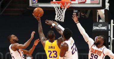 Los Angeles Lakers' LeBron James (23) drives to the basket against Phoenix Suns players, in a preseason game in Arizona, Dec. 18, 2020. (REUTERS PHOTO)