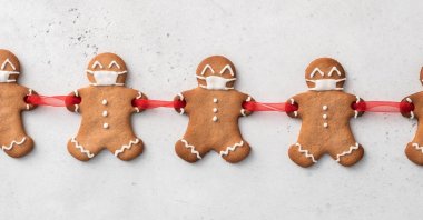 Cut out holes in your gingerbread men's hands before cooking to join them together with a ribbon and add icing masks. (Shutterstock Photo)