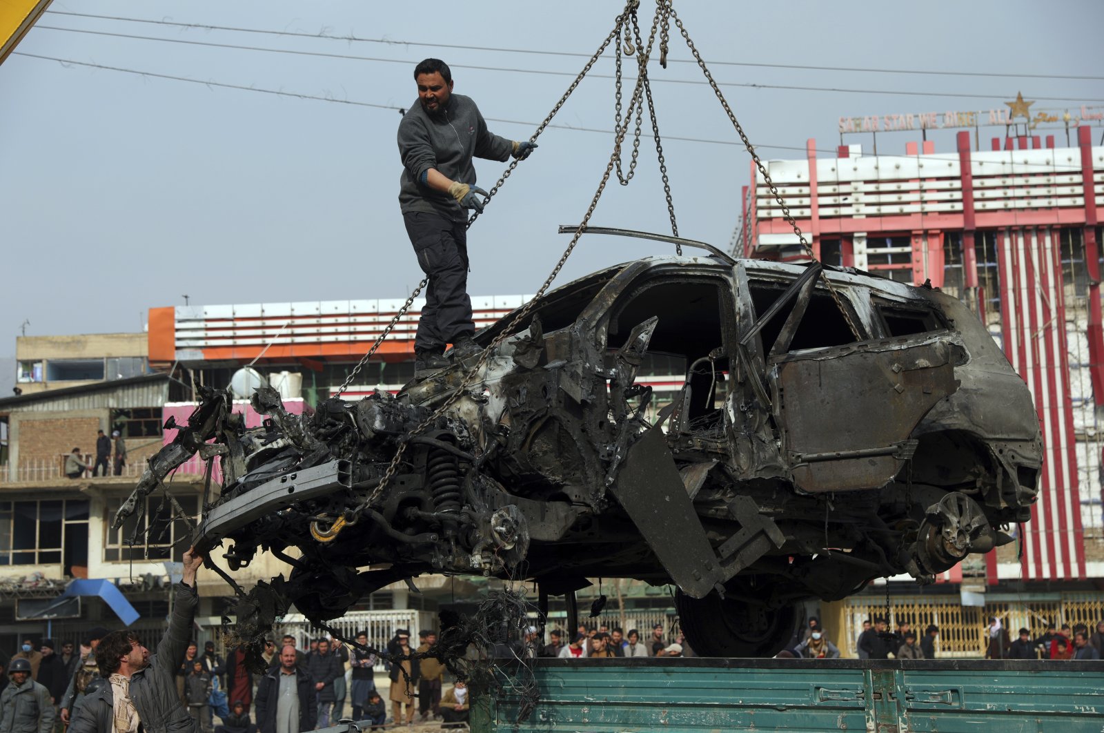 Afghan security personnel oversees the removal of damaged vehicles after a bombing in Kabul, Afghanistan, Dec. 20, 2020. (AP Photo)
