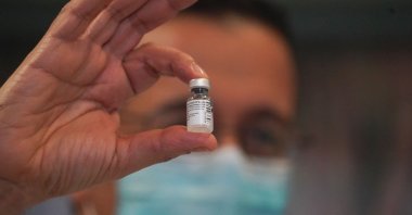 An employee holds up a vial of the Pfizer-BioNTech COVID-19 vaccine at The New Jewish Home long-term care facility on Manhattan, Upper West Side in New York on Dec. 21, 2020. (AFP Photo)