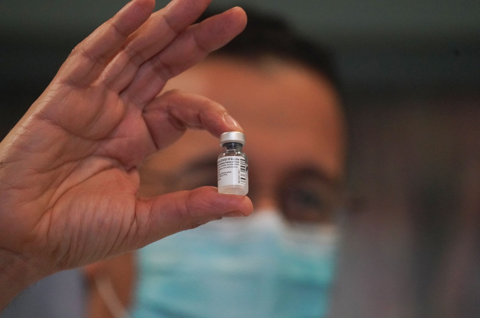 An employee holds up a vial of the Pfizer-BioNTech COVID-19 vaccine at The New Jewish Home long-term care facility on Manhattan, Upper West Side in New York on Dec. 21, 2020. (AFP Photo)