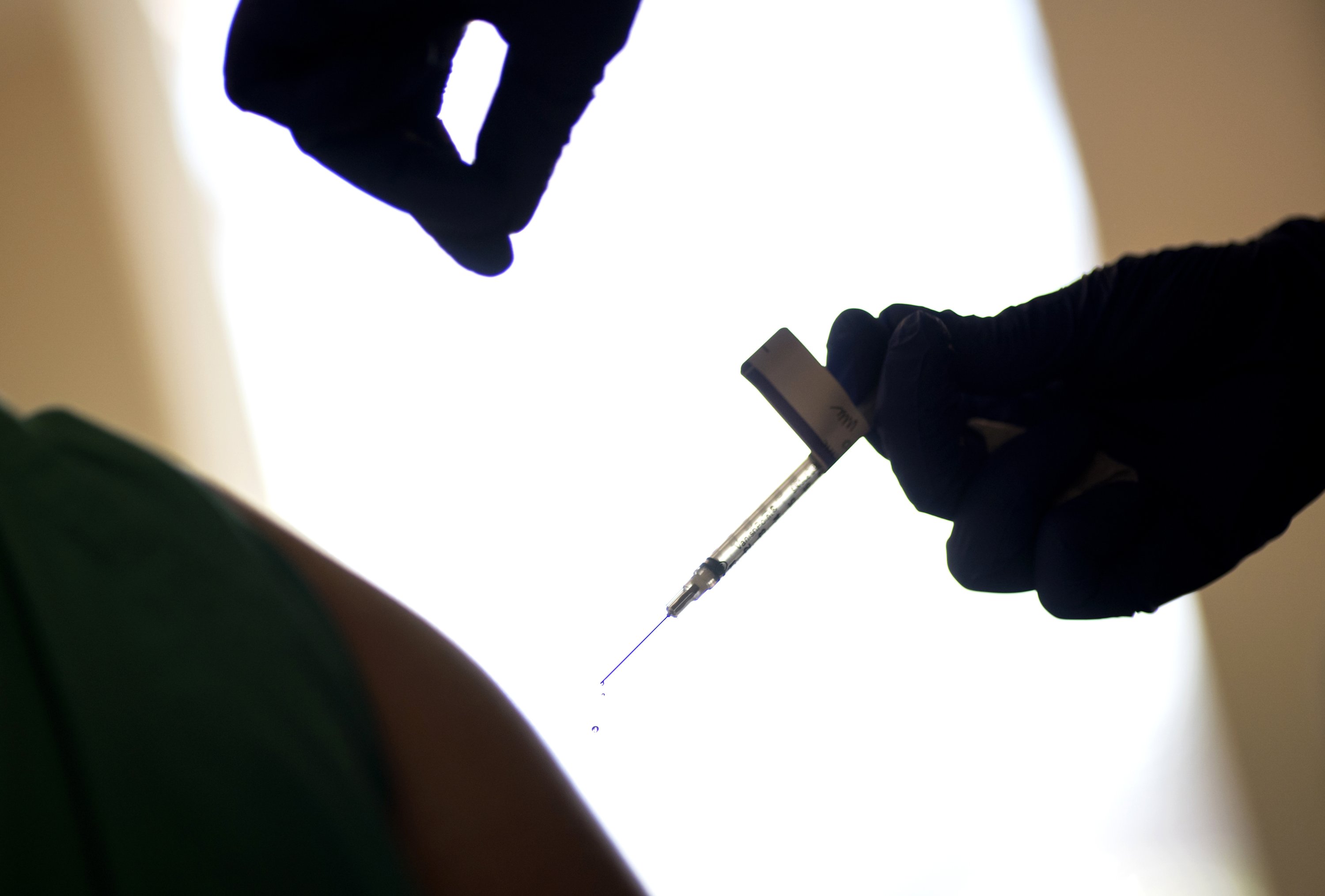 In this Tuesday, Dec. 15, 2020, file photo, a droplet falls from a syringe after a health care worker was injected with the Pfizer-BioNTech COVID-19 vaccine at a hospital in Providence, R.I. (AP Photo)