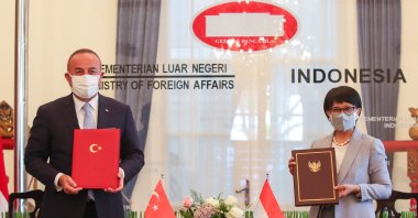 Turkey's Foreign Minister Mevlüt Çavuşoğlu (L) and his Indonesian counterpart Retno Marsudi sign a MoU in Jakarta, Indonesia, Dec. 22, 2020. (AA Photo)