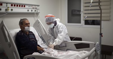 Nurse Mevlüde Altan tends to İsmail Demir infected with COVID-19, at the intensive care unit of the Prof. Dr. Feriha Oz Emergency Hospital, in Istanbul, Turkey, Dec. 19, 2020. (AP PHOTO) 