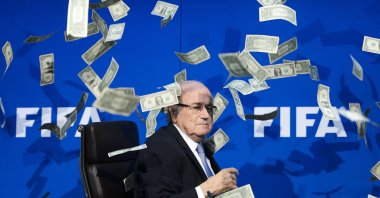 FIFA president Sepp Blatter looks on as fake dollar notes fly around him, in Zurich, Switzerland, Jul. 20, 2015.  (AFP PHOTO) 