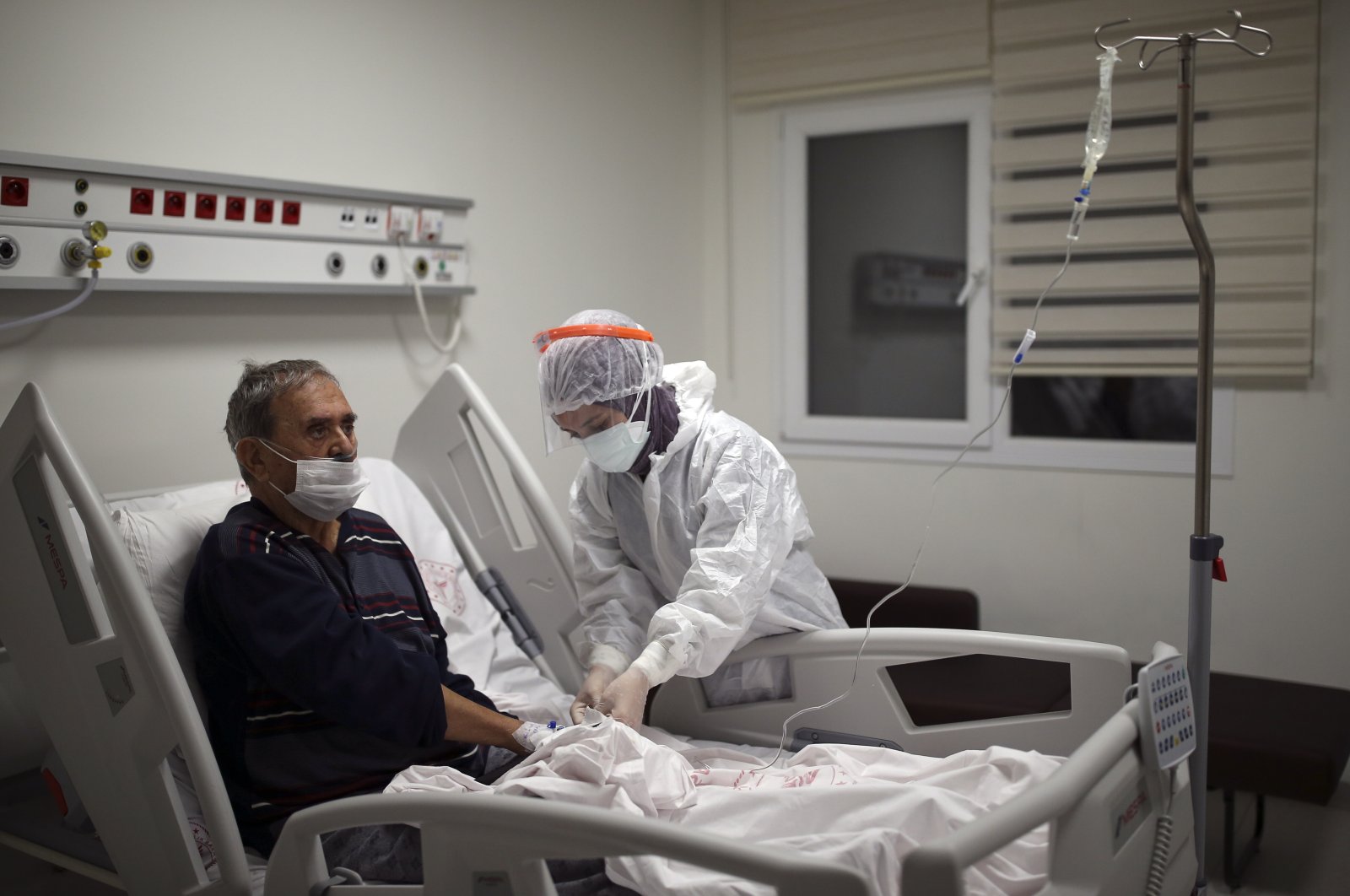 Nurse Mevlüde Altan tends to İsmail Demir infected with COVID-19, at the intensive care unit of the Prof. Dr. Feriha Oz Emergency Hospital, in Istanbul, Turkey, Dec. 19, 2020. (AP PHOTO) 