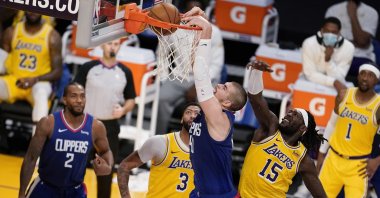 The Los Angeles Clippers' Ivica Zubac (C) dunks past Los Angeles Lakers' Montrezl Harrell (R) during the second half of an NBA basketball game in Los Angeles, California, Dec. 22, 2020. (AP Photo)
