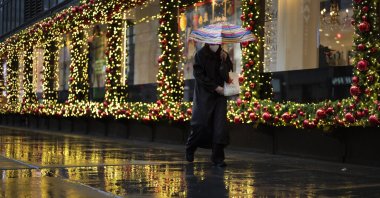 A shopper walks by holiday window displays in New York, U.S., Nov. 30, 2020. (AP Photo)