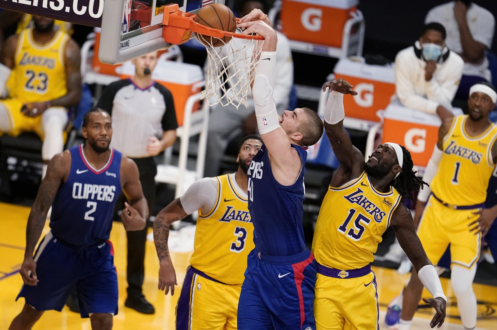 The Los Angeles Clippers' Ivica Zubac (C) dunks past Los Angeles Lakers' Montrezl Harrell (R) during the second half of an NBA basketball game in Los Angeles, California, Dec. 22, 2020. (AP Photo)
