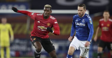 Manchester United's Paul Pogba (L) takes the ball away from Everton's Gylfi Sigurdsson during the English League Cup quarterfinal match at Goodison Park, in Liverpool, England, Dec. 23, 2020. (AP Photo)