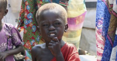 Three-year-old Peter Sebit stands outside a health clinic waiting to receive food supplements in Pibor, South Sudan, Dec. 17, 2020. (AP Photo)