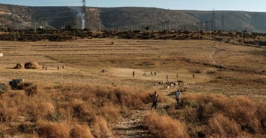 Children play soccer while sheep graze in a field on the outskirts of the city of Mekelle, Ethiopia, Jan. 5, 2020. (AFP Photo)