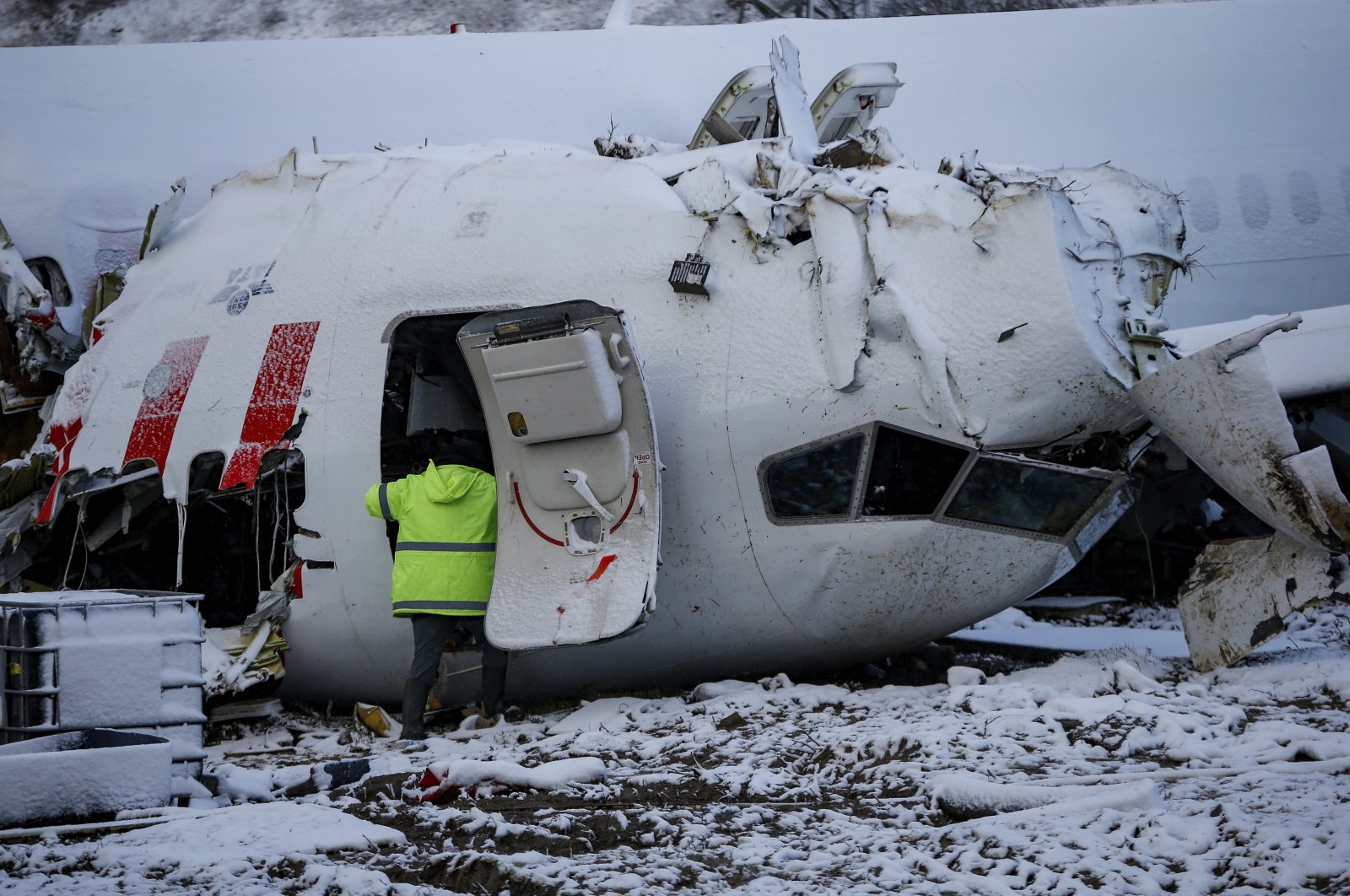Investigators work at the wreckage of the Pegasus Airlines plane that crash-landed at Sabiha Gökçen Airport, in Istanbul, Turkey, Feb. 8, 2020. (AP Photo)