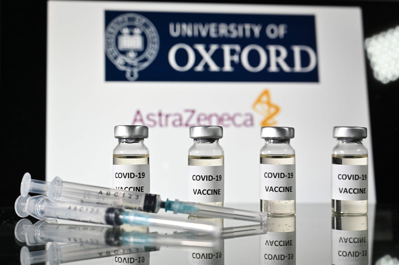 An illustration picture shows vials with COVID-19 Vaccine stickers attached and syringes, with the logo of the University of Oxford and its partner British pharmaceutical company AstraZeneca, Nov. 17, 2020  (AFP Photo)