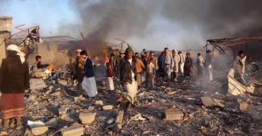 Smoke rises as Yemenis inspect the damage at the site of airstrikes in the northwestern Houthi-held city of Saada, Jan. 06, 2018.