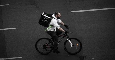 A delivery man working for Uber Eats rides a bicycle in Paris amid the coronavirus outbreak, April 20, 2020. (AFP Photo)