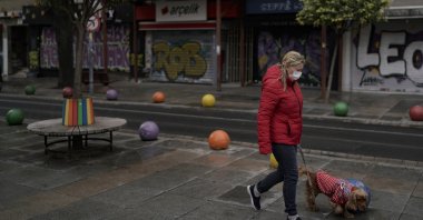 A woman wearing a protective mask walks her dog during a weekend curfew in Kadıköy district, in Istanbul, Turkey, Dec. 27, 2020. (DHA PHOTO)