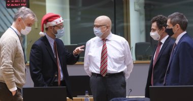 A colleague wears a Christmas hat as he speaks with EU ambassadors and representatives during a special meeting of Coreper, at the European Council building in Brussels, Belgium, Dec. 25, 2020. (AP Photo)