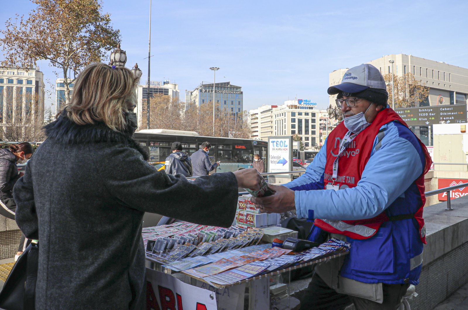 A woman buys a lottery ticket from a vendor, in the capital Ankara, Turkey, Dec. 26, 2020. (AA PHOTO) 
