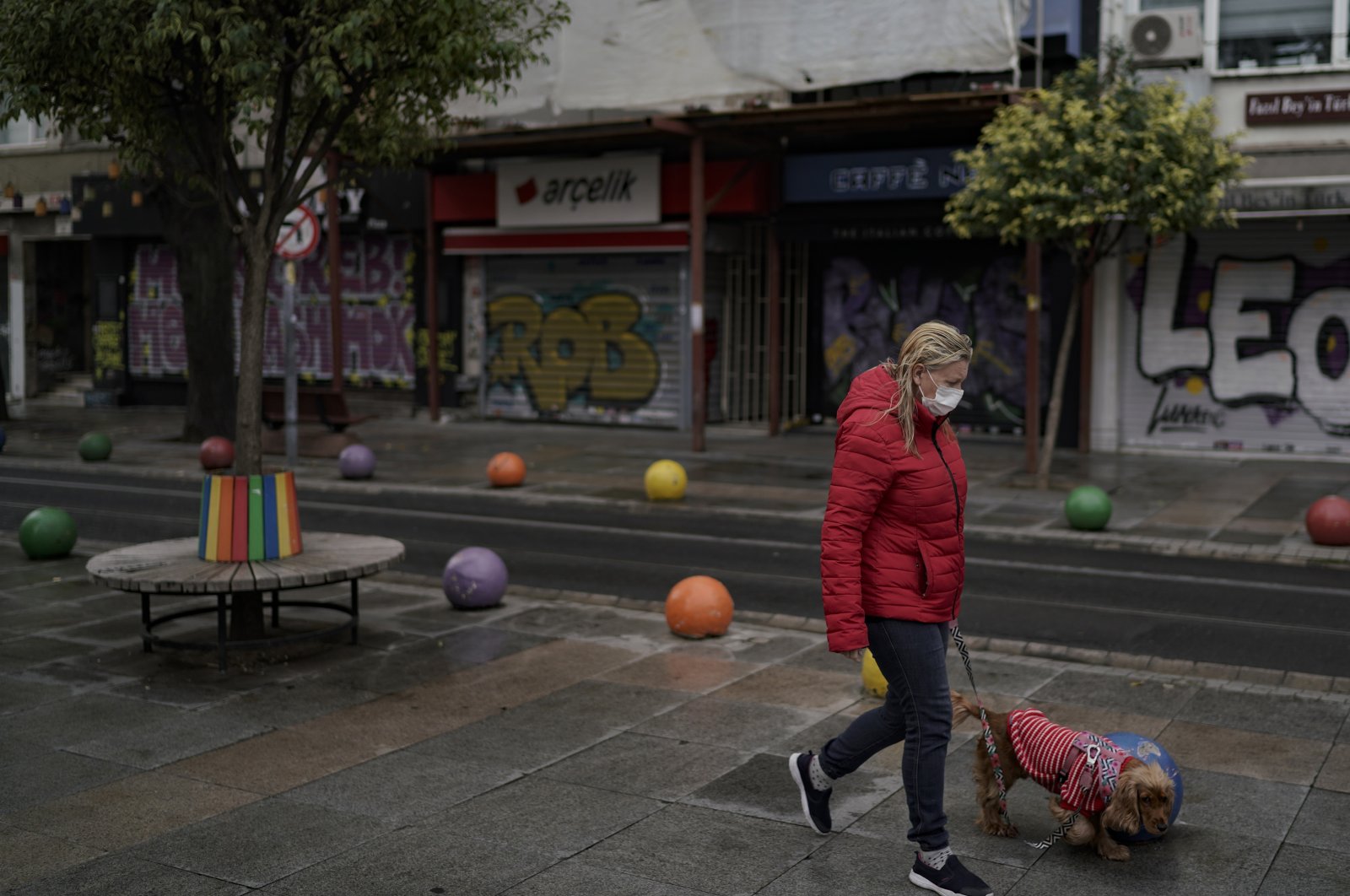 A woman wearing a protective mask walks her dog during a weekend curfew in Kadıköy district, in Istanbul, Turkey, Dec. 27, 2020. (DHA PHOTO)