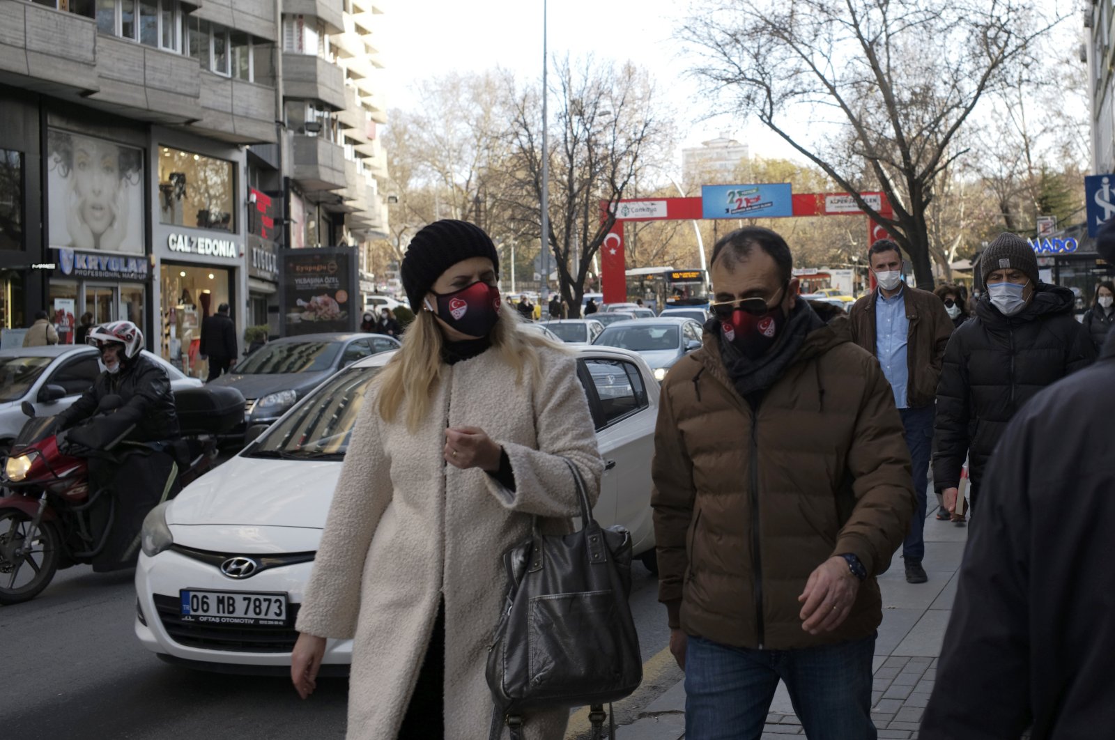 People wearing masks walk along a street hours before a two-day weekend lockdown, in Ankara, Turkey, Dec. 25, 2020. (AP Photo)