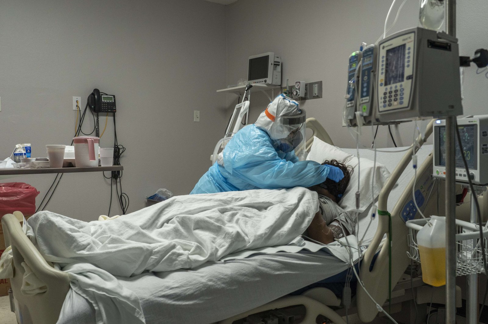 Medical staff member Mantra Nguyen installs a new oxygen mask for a patient in the COVID-19 intensive care unit (ICU) at the United Memorial Medical Center on Dec. 28, 2020 in Houston, Texas. (AFP Photo)