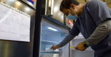 A nurse retrieves COVID-19 vaccine doses from a refrigerator at the Bahrain International Exhibition and Convention Center in the capital Manama, Bahrain, Dec. 24, 2020. (AFP Photo)