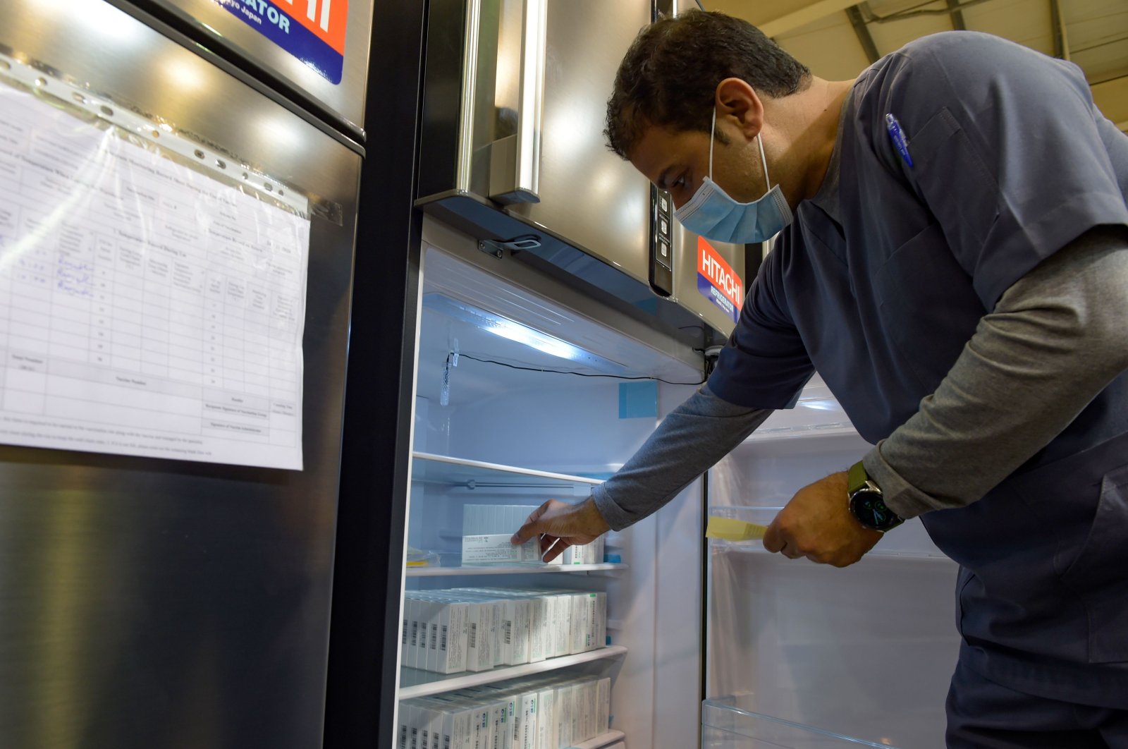 A nurse retrieves COVID-19 vaccine doses from a refrigerator at the Bahrain International Exhibition and Convention Center in the capital Manama, Bahrain, Dec. 24, 2020. (AFP Photo)
