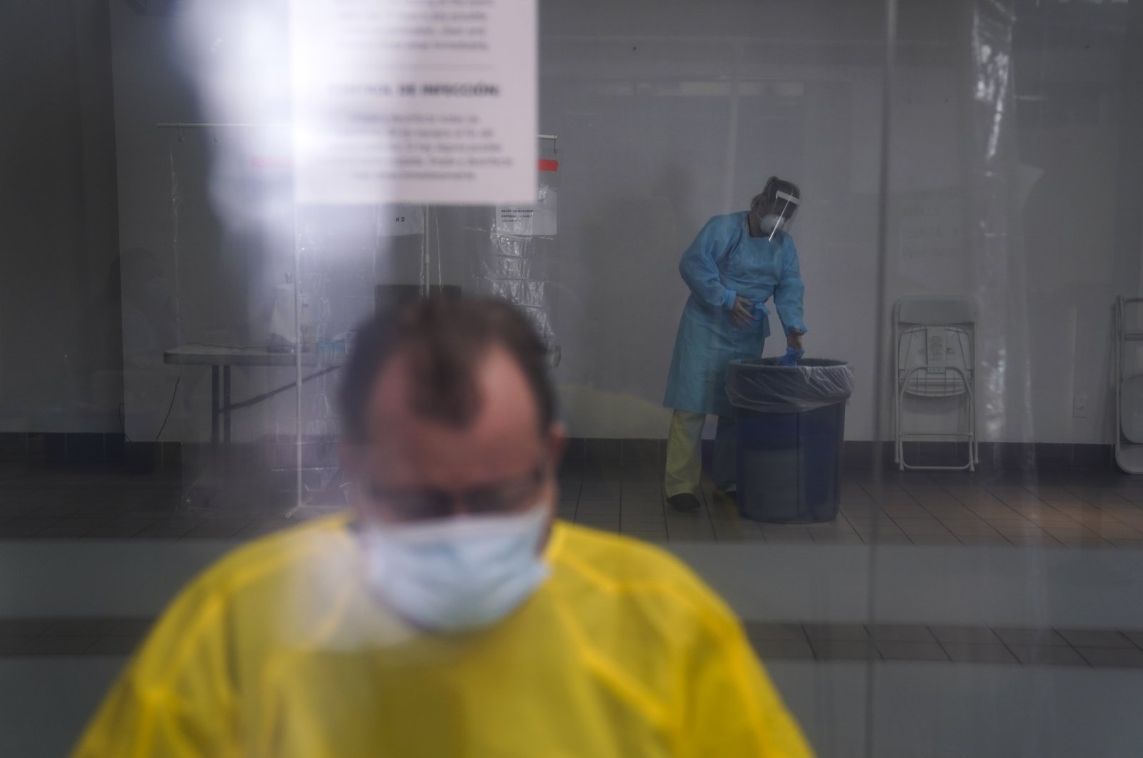Registered nurse Leslie Clark discards her protective gloves after collecting a nasal swab sample from a woman at a COVID-19 testing site in Los Angeles, Sunday, Dec. 27, 2020. (AP Photo)