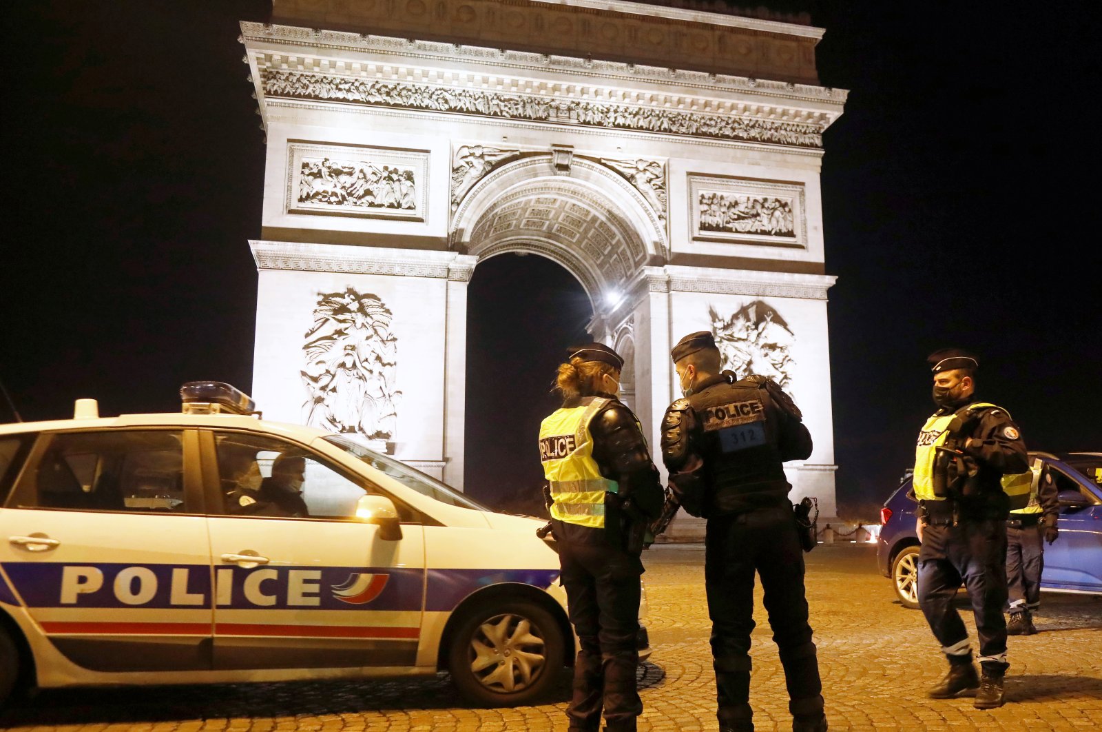 French police patrol in front of the Arc de Triomphe on Champs Elysees avenue on New Year's Eve, after celebrations and gatherings were banned due to coronavirus restrictions, in Paris, France, Dec. 31, 2020. (Reuters Photo)
