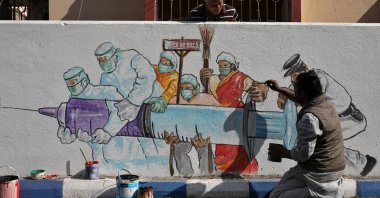 A man applies finishing touches to graffiti representing a vaccine, amidst the spread of coronavirus disease (COVID-19) in Kolkata, India, Jan. 2, 2021. (Reuters Photo)