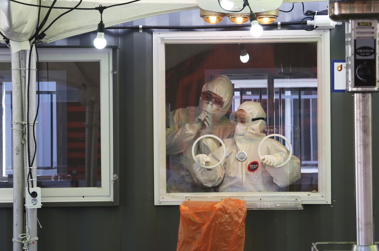Medical workers in a booth work during COVID-19 testing at a makeshift clinic in Seoul, South Korea, Saturday, Jan. 2, 2021. (AP Photo)