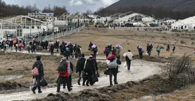 Migrants walk back to the Lipa camp after hundreds failed to be relocated from the burnt-out tent camp in the northwest of the country, outside Bihac, Bosnia-Herzegovina, Dec. 30, 2020. (AP Photo)
