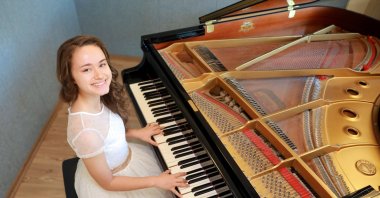 Nehir Özzengin sits at her piano in Izmir, western Turkey, July 4, 2019. (Photo by Ceyda Karaaslan Özyiğit)