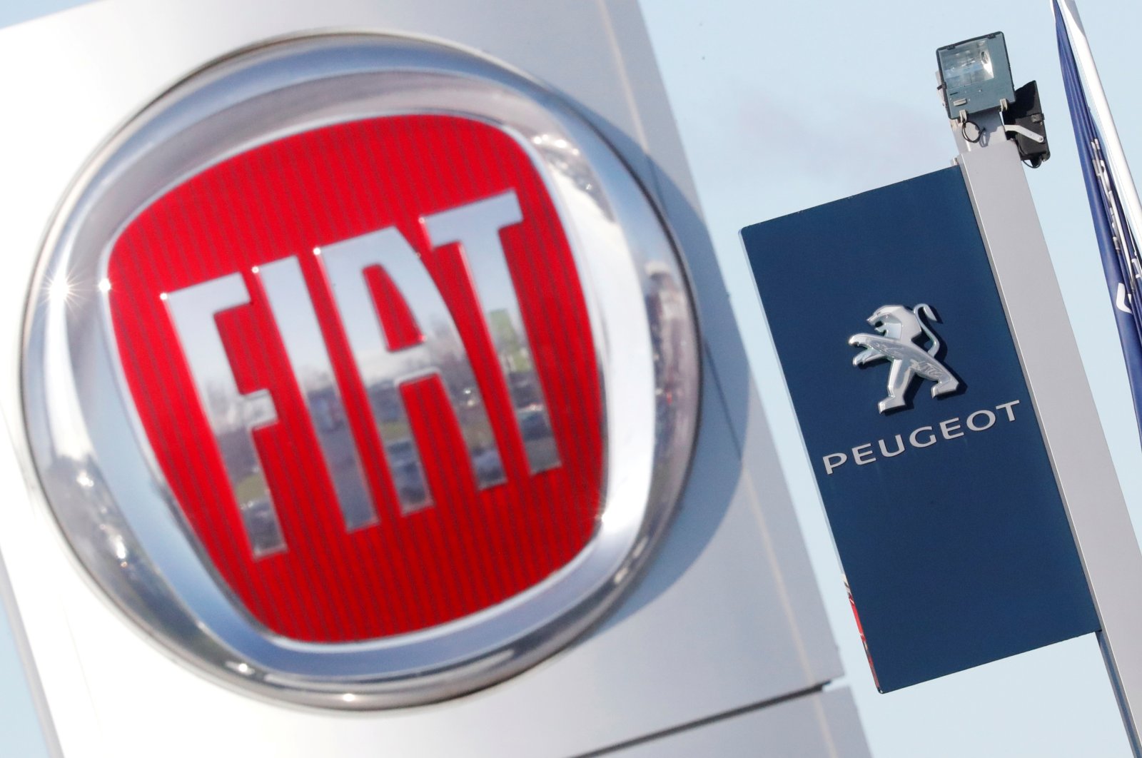 The logos of car manufacturers Fiat and Peugeot are seen in front of dealerships of the companies in Saint-Nazaire, France, Nov. 8, 2019. (Reuters Photo)