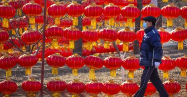 A man wearing a face mask to protect against the spread of the coronavirus walks past a display of lanterns at a public park in Beijing, Jan. 5, 2021. (AP Photo)