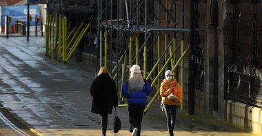 Pedestrians, some wearing masks or face coverings, walk along an almost empty street in Manchester, north west England on Jan. 5, 2021, as Britain enters a second national lockdown to combat the spread of COVID-19. (AFP Photo)