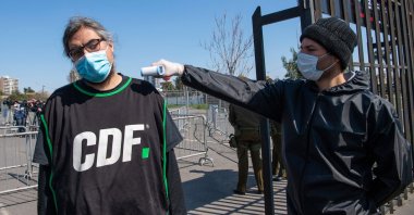 A journalist gets his temperature checked at the gates of Monumental stadium before the start of a football match between Colo-Colo and the Wanderers for the national championship during the COVID-19 pandemic in Santiago, Chile, Aug. 29, 2020. (AFP Photo)
