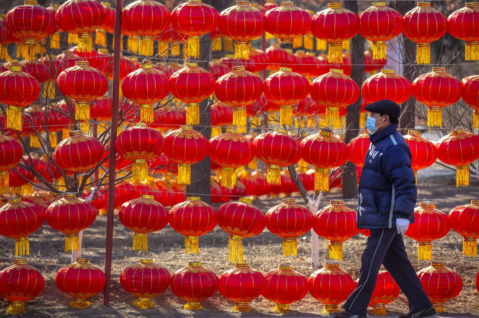 A man wearing a face mask to protect against the spread of the coronavirus walks past a display of lanterns at a public park in Beijing, Jan. 5, 2021. (AP Photo)