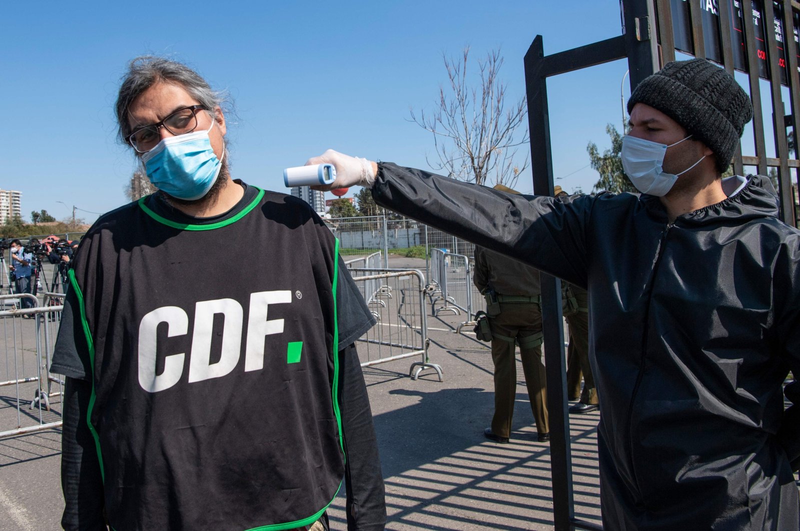 A journalist gets his temperature checked at the gates of Monumental stadium before the start of a football match between Colo-Colo and the Wanderers for the national championship during the COVID-19 pandemic in Santiago, Chile, Aug. 29, 2020. (AFP Photo)