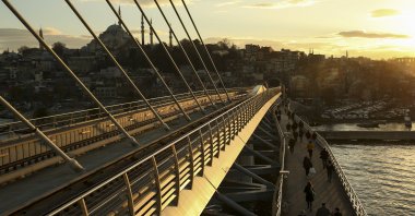 Backdropped by the Süleymaniye Mosque, people walk on the Golden Horn Bridge, over the Golden Horn in Istanbul, Turkey, Dec. 30, 2020. (AP Photo)