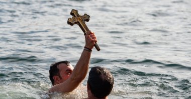 Orthodox faithful Vasili Kürkçü celebrates as he retrieves the wooden cross, in Istanbul, Turkey, Jan. 6, 2021. (AFP Photo)