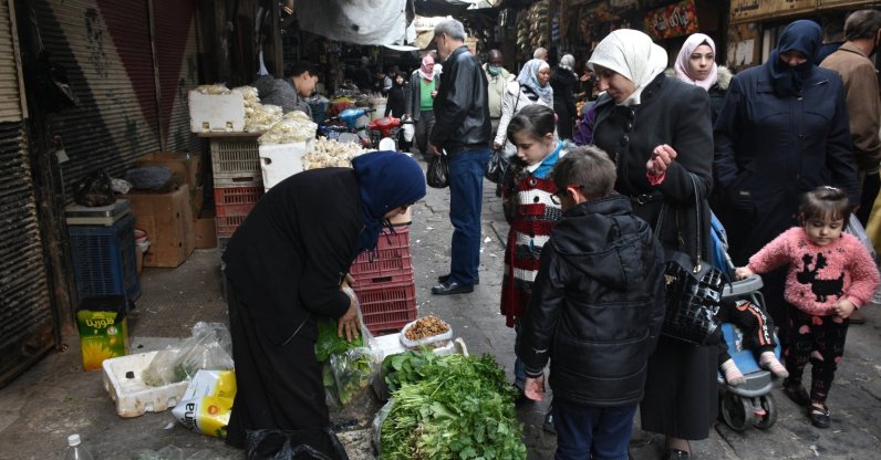 Syrians buy basic food items and other necessities on a street in Damascus, Syria, Jan. 5, 2021.  (EPA Photo)