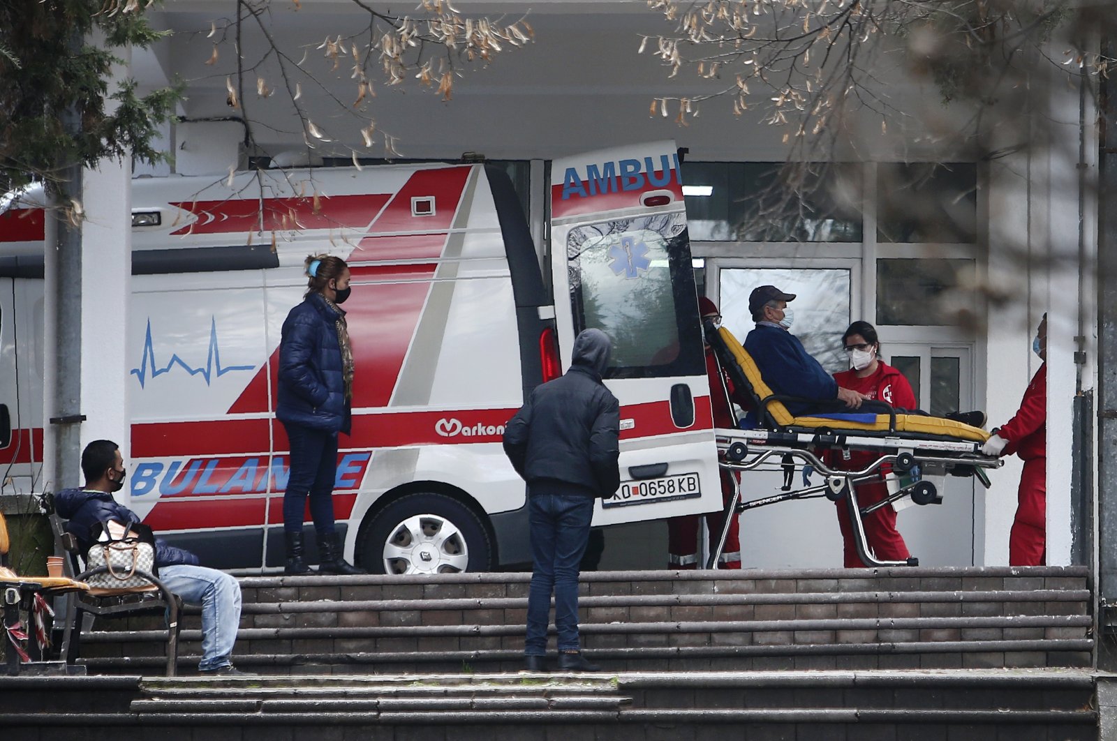 Health workers wheel out a patient from an ambulance, at the entrance of the University Clinic complex in Skopje, North Macedonia, Dec. 29, 2020. (AP Photo)