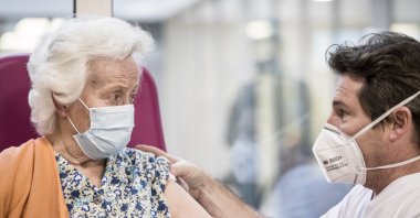 A nurse talks to a resident after administering a Pfizer/BioNTech COVID-19 vaccine at the Ange-Raymond Gilles care home in Jemeppe-sur-Meuse, near Liege, Belgium, Tuesday, Jan. 5, 2021. (AP Photo)