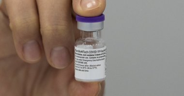 An employee of the Municipal Health Service GGD shows the Pfizer-BioNTech COVID-19 vaccine prior to administering it to a health care worker at a coronavirus vaccination facility in Houten, central Netherlands, Jan. 8, 2021. (AP Photo)