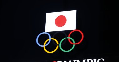 The Olympic rings and a Japanese flag on display at the Japan Olympic Museum building in Tokyo, Japan, Jan. 8, 2021. (AFP Photo)