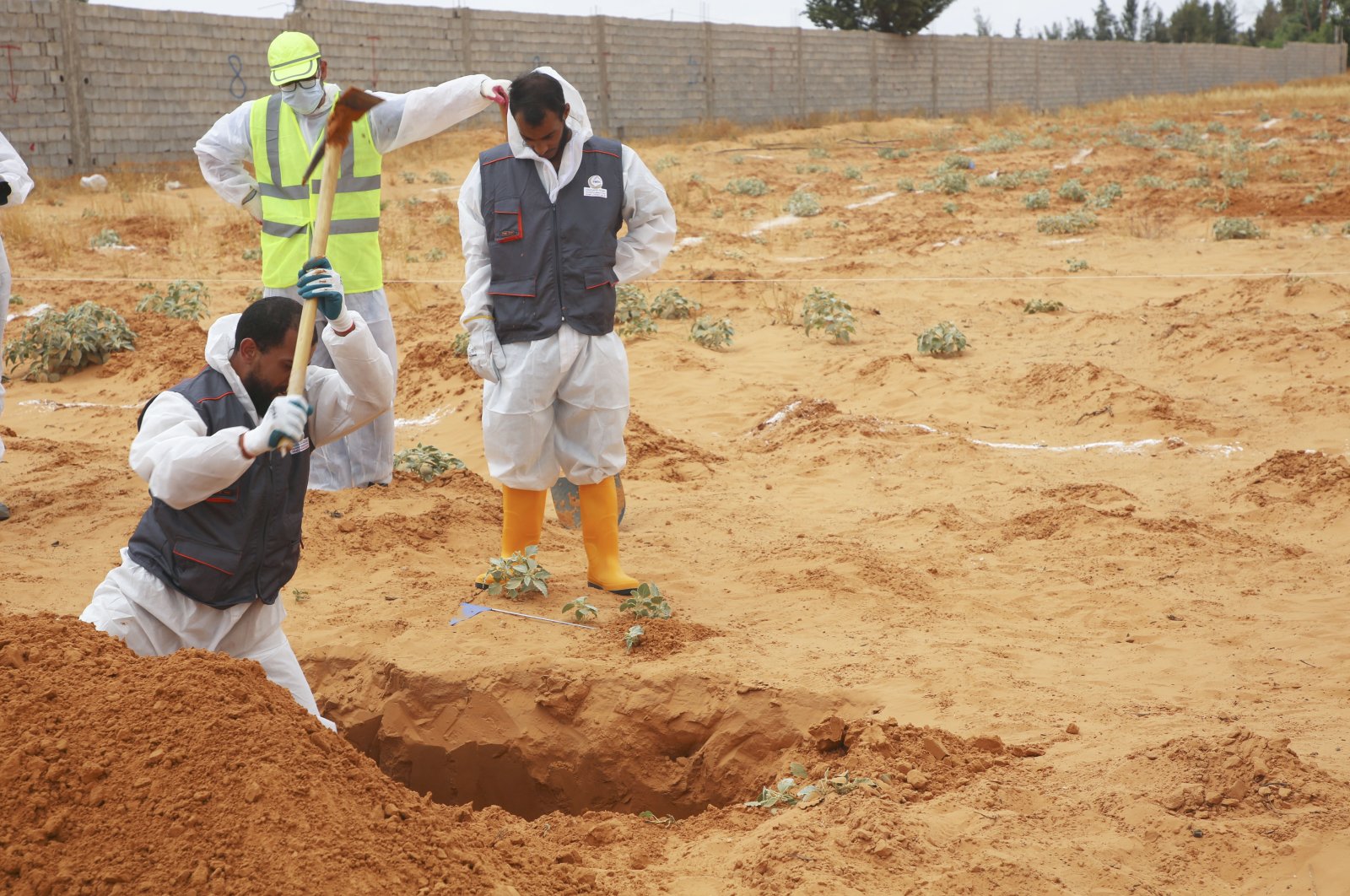 Libyan Ministry of Justice employees dig at a site of a suspected mass grave in the town of Tarhuna, Libya, June 23, 2020 (AP Photo)