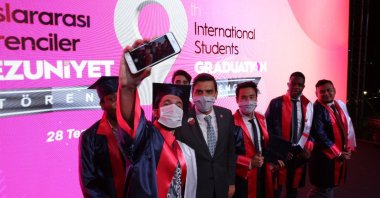 Students pose with YTB President Abdullah Eren (C) during graduation ceremony, in the capital Ankara, Turkey, July 28, 2020. (Photo courtesy of YTB)